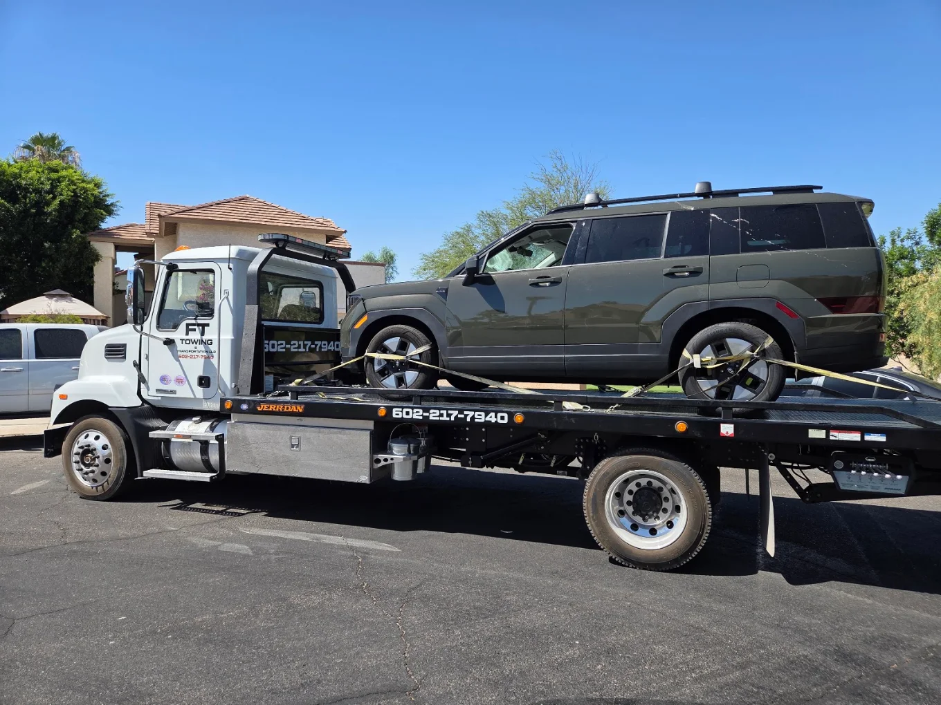 FT Towing rollback truck carrying an SUV